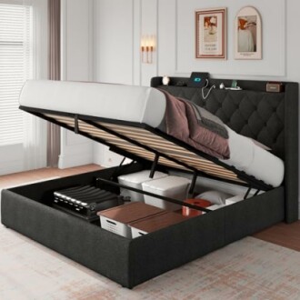 Lift-up storage bed frame with items stored underneath in a bedroom.