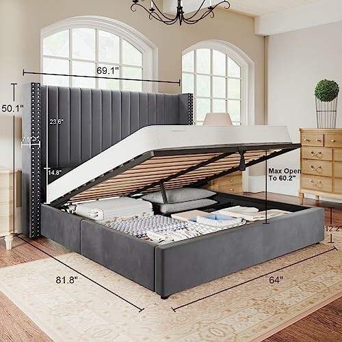 Upholstered storage bed frame with open lift showing bedding storage.